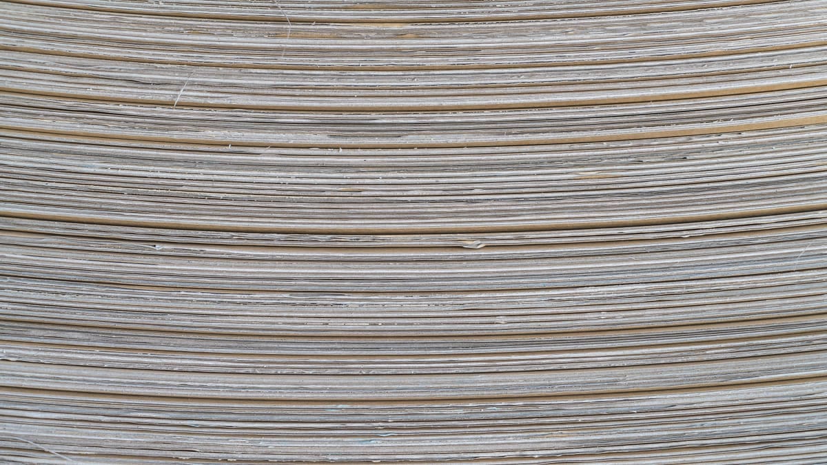Folhas de papel de gramaturas diferentes empilhadas em degrau, da mais fina à mais grossa, com etiquetas de g/m²