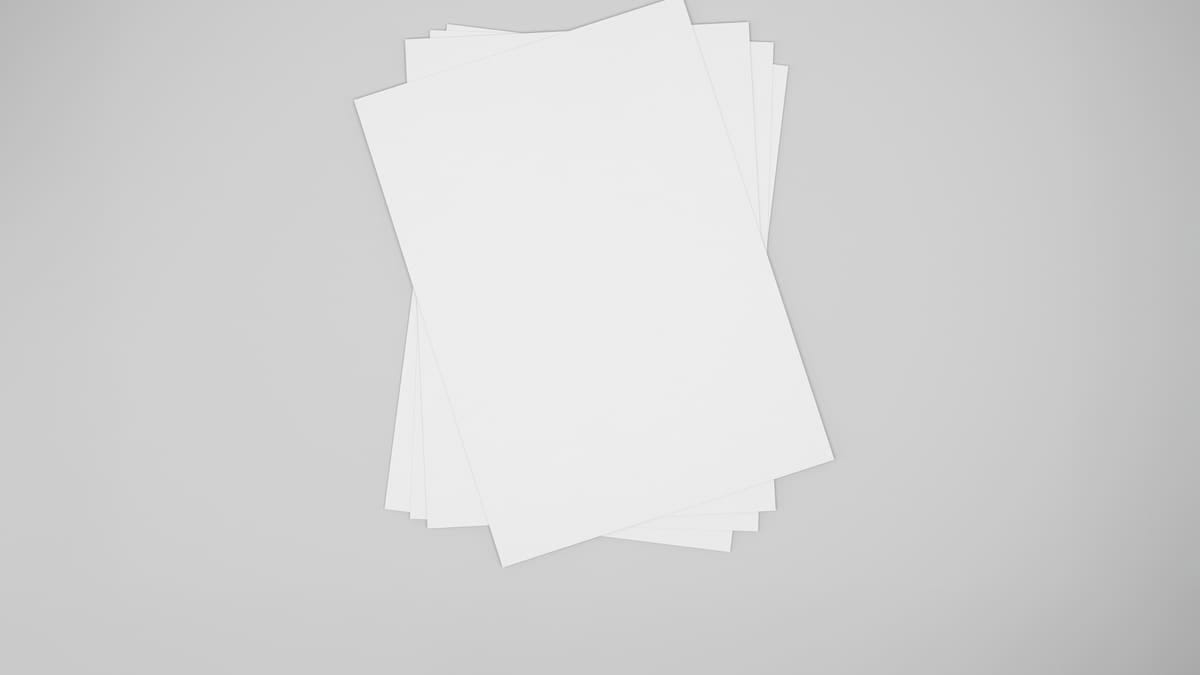 Resmas de papel sulfite A4 de marcas diferentes empilhadas ao lado de uma impressora